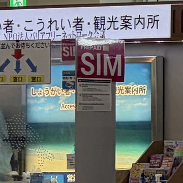 那覇空港の観光案内所に立つプリペイドSIMの案内