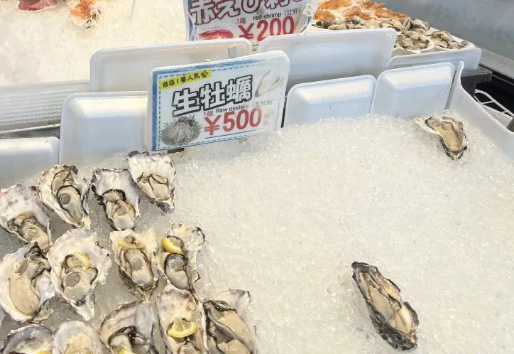 お魚センターの生牡蠣の売り場。1個500円と書かれた値札が立っている