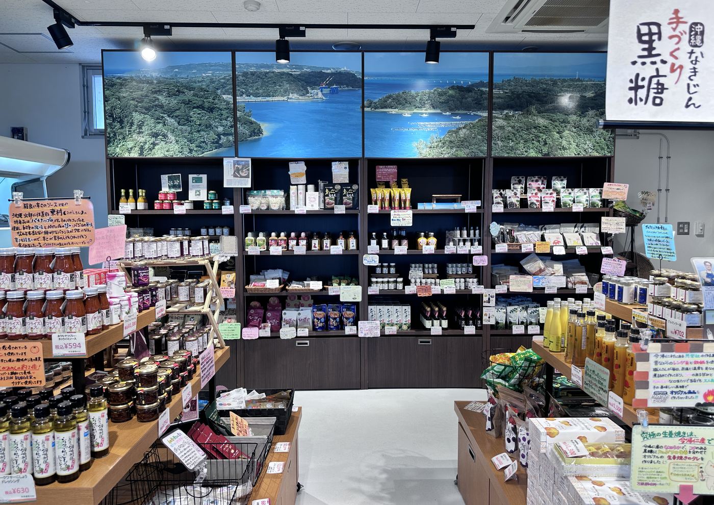 黒糖の黒板が掛かった直売所の売り場。かごに小袋の菓子が盛られている