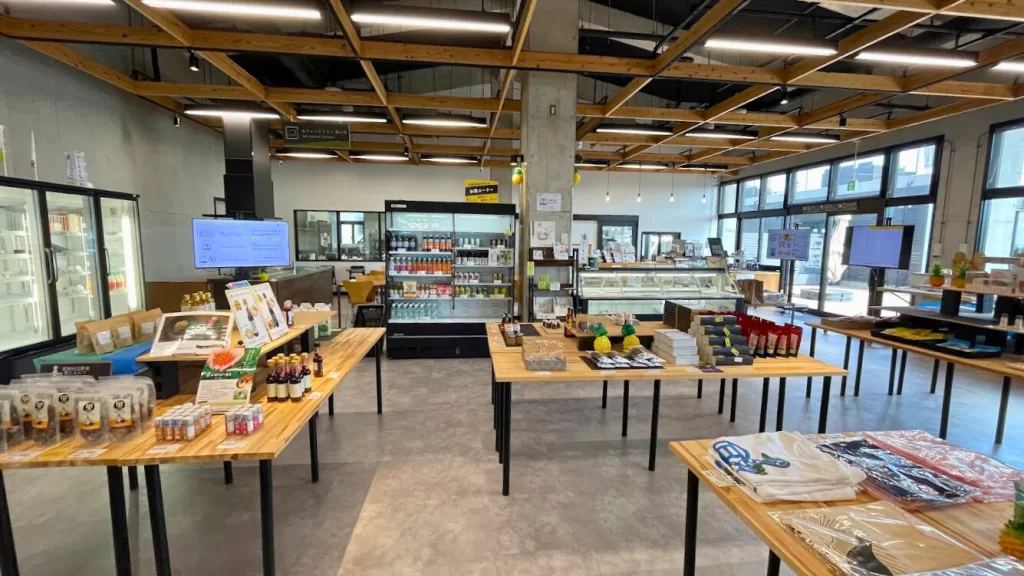 やんばるパイナップルの丘 安波の物販コーナー。木のテーブルに商品が並ぶ
