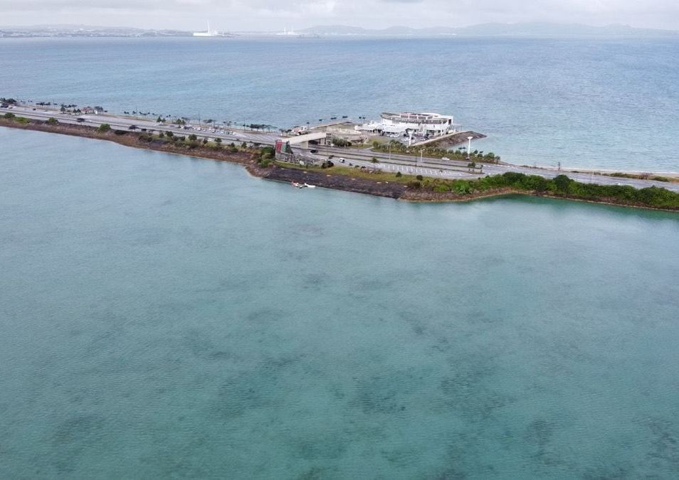 浅い海を貫く海中道路を車が走る、沖縄のドライブ