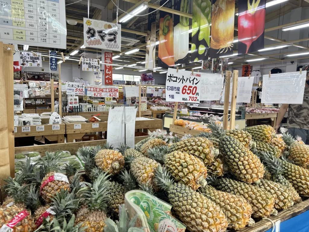 菜々色畑のパイナップル売り場。値札のついたパイナップルが山積みになっている